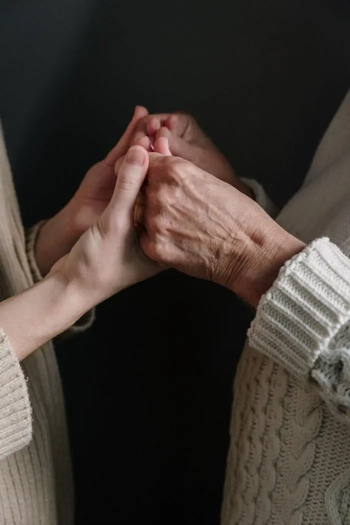 Two generations connect through holding hands, symbolizing love and unity.